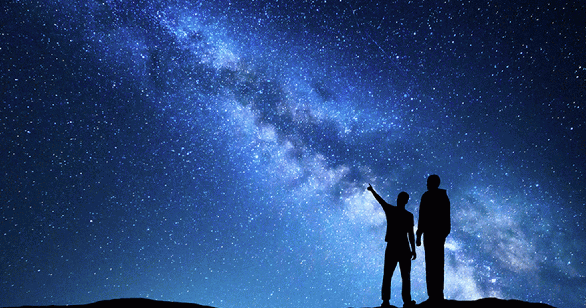 Milky Way with silhouette of men. Father and a son who pointing finger in night starry sky on the mountain. Night landscape. Silhouette of family on the background of beautiful galaxy. Space.