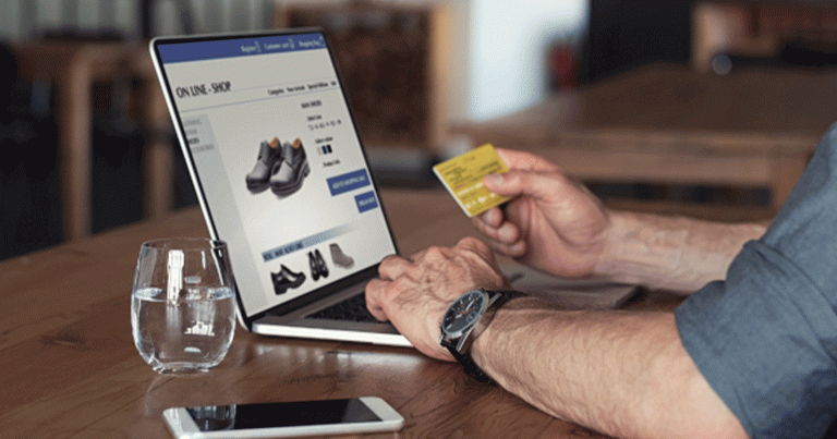 Senior businessman using debit card to make online transaction using laptop. Mature business man doing shopping online banking. Man making online payment with credit card and laptop.